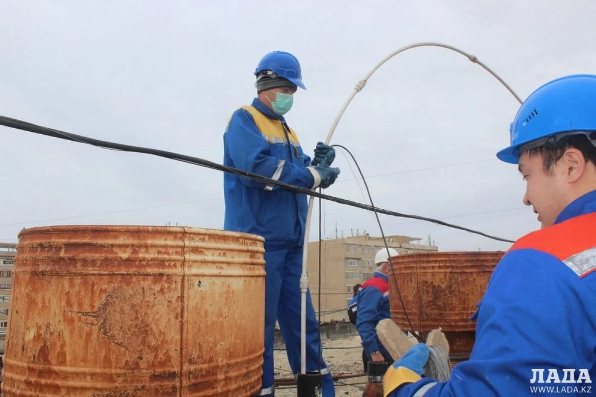 Сотрудники ТОО «Каспий жылу, су арнасы» устанавливают заглушки на крыше дома 27 в 27 микрорайоне. Фото автора