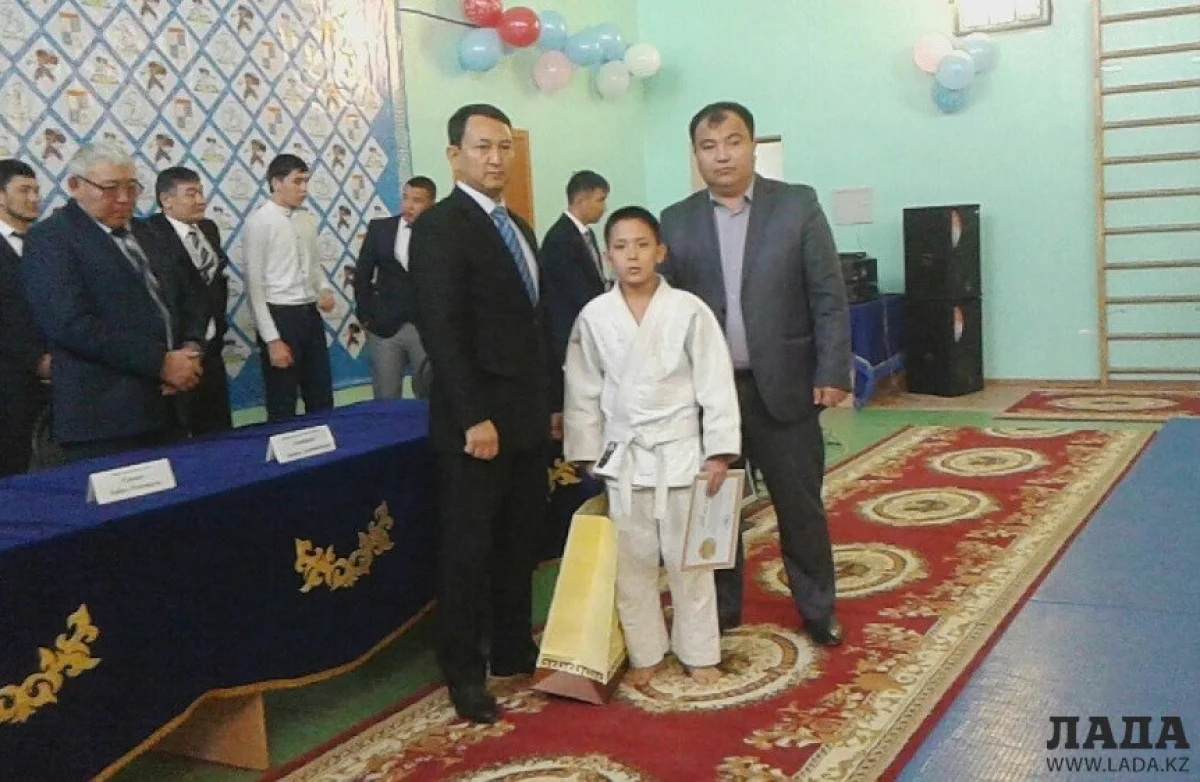 Аким вручает приз ЖанибекуТлеубекову, победителю и призеру республиканских турниров, одному из лучших спортсменов села Умирзак, кандидату в мастера спорта РК. Фото горспортотдела