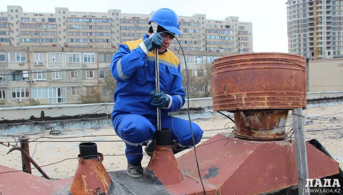 Сотрудники ТОО «Каспий жылу, су арнасы» устанавливают заглушки на крыше дома 44 в 14 микрорайоне. Фото автора