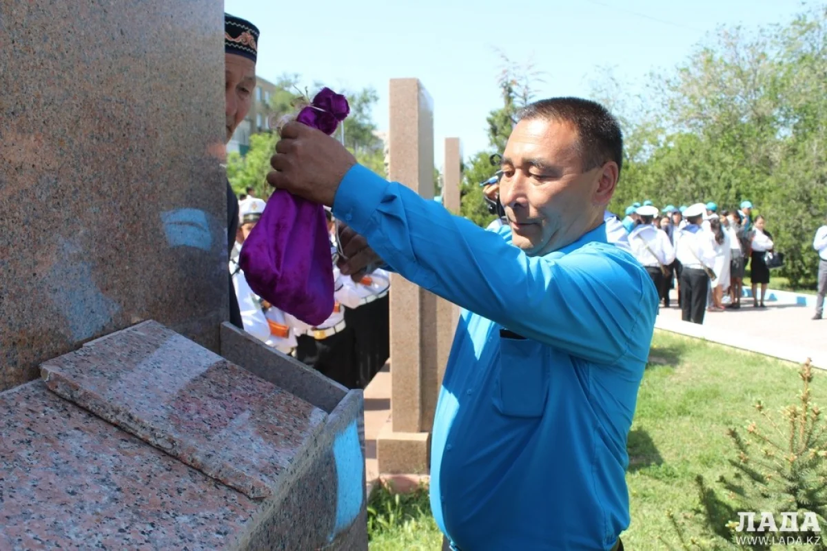 Курал Карабалаев, родственник Джумагали Калдыкараева кладёт землю в стелу. Фото автора