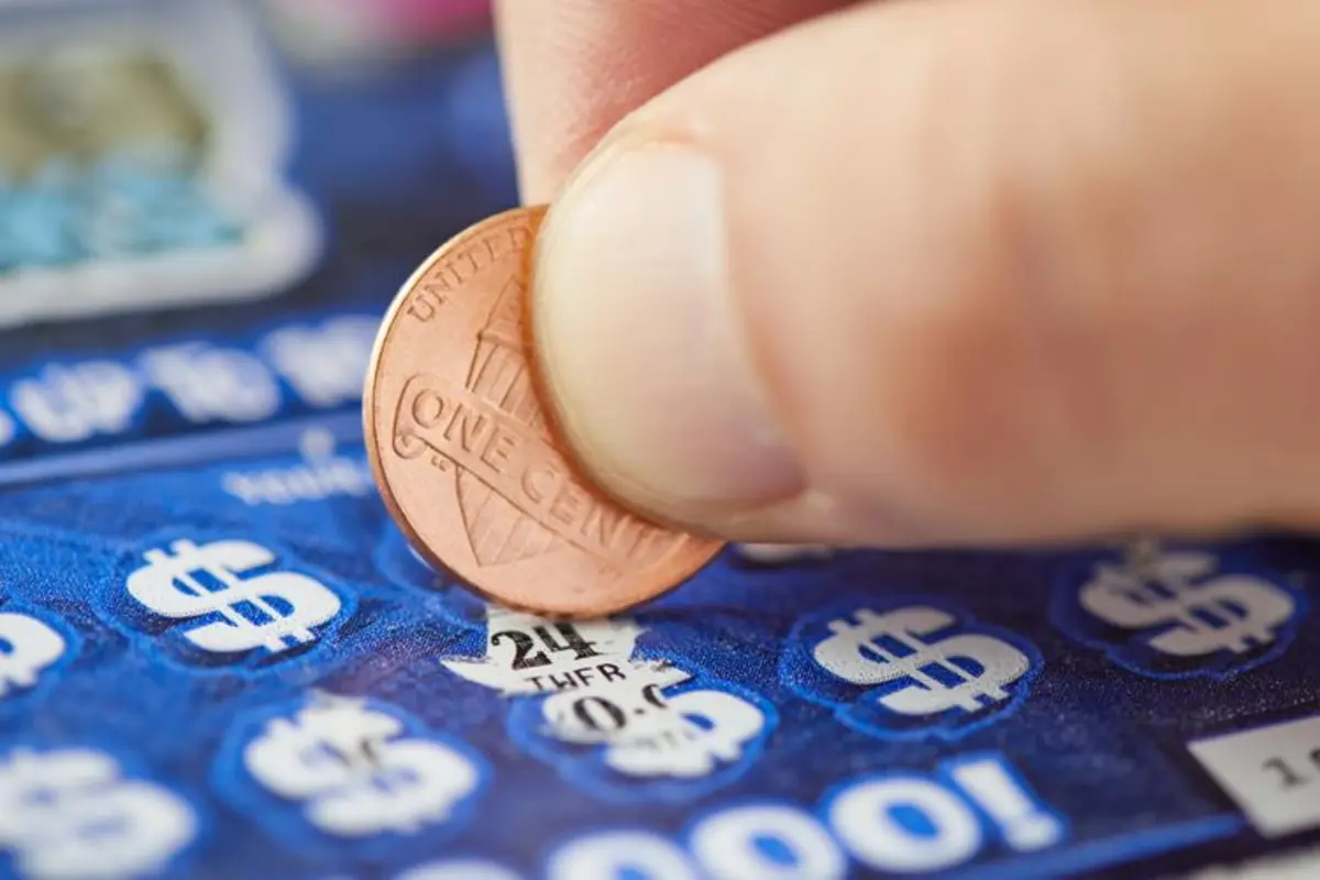 Person playing a lottery scratch off card (stock image). Credit :  Getty