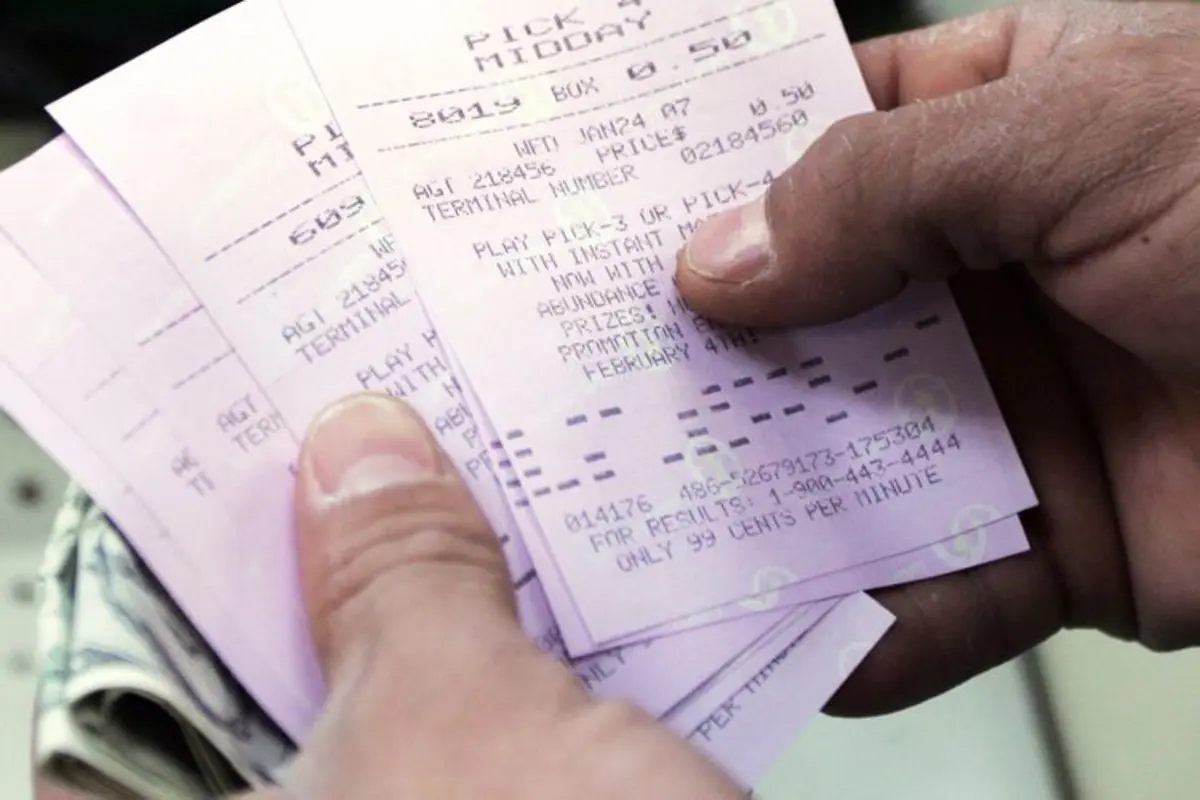 Stock image of a man holding lottery tickets. Credit: Emile Wamsteker/Bloomberg via Getty