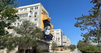 В Актау сильный ветер сорвал баннер с жилого дома