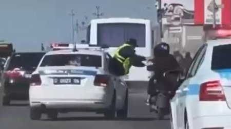 Полицейский в Атырау вылез в окно авто, чтобы задержать мопедиста прямо на ходу